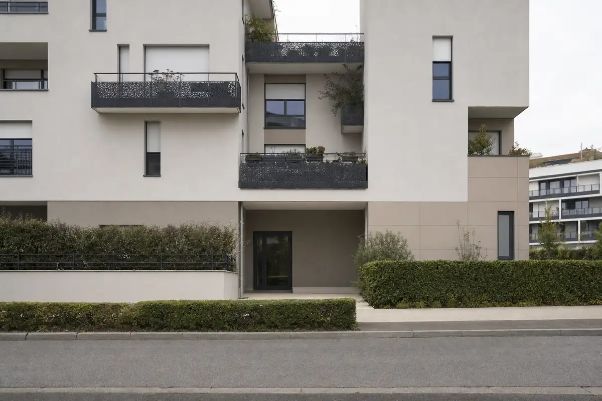 Rue résidentielle du quartier Pointe du Lac à Créteil, façade d'immeuble récent sans aucune enseigne visible.